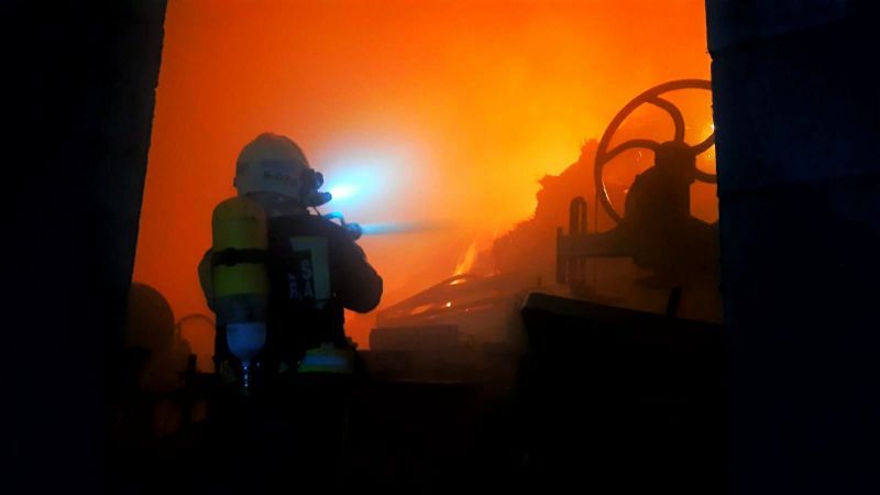 Efectivos de emergencias trabajan en la extinción de un incendio en una nave ganadera de Cabezón de la Sal